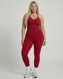Model wearing a red seamless halter sculpt leggings set with high waist fitted leggings and athletic sneakers.