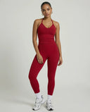 Model wearing a red seamless halter sculpt leggings set with high waist fitted leggings and athletic sneakers.