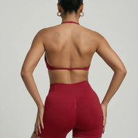 Model wearing a red seamless sculpt gym set with high waist shorts and a supportive sports bra paired with athletic sneakers.