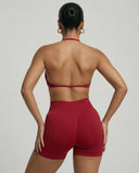 Model wearing a red seamless sculpt gym set with high waist shorts and a supportive sports bra paired with athletic sneakers.