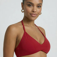 Model wearing a red seamless sculpt gym set with high waist shorts and a supportive sports bra paired with athletic sneakers.