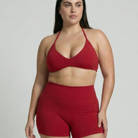 Model wearing a red seamless sculpt gym set with high waist shorts and a supportive sports bra paired with athletic sneakers.