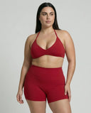 Model wearing a red seamless sculpt gym set with high waist shorts and a supportive sports bra paired with athletic sneakers.