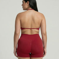 Model wearing a red seamless sculpt gym set with high waist shorts and a supportive sports bra paired with athletic sneakers.