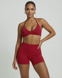 Model wearing a red seamless sculpt gym set with high waist shorts and a supportive sports bra paired with athletic sneakers.