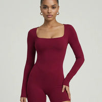 Woman wearing a sculpting long sleeve square neck fitted romper with athletic silhouette in red.