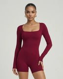Woman wearing a sculpting long sleeve square neck fitted romper with athletic silhouette in red.