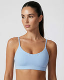 Woman wearing a seamless medium support workout sports bra with a smooth sculpting fit and minimalist design.