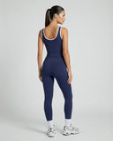Woman wearing seamless sculpt high waist gym set with tank top and leggings in navy blue, shown from front and back.

