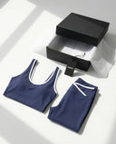 Woman wearing seamless sculpt high waist gym set with tank top and leggings in navy blue, shown from front and back.