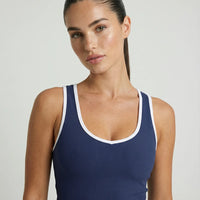 Woman wearing seamless sculpt high waist gym set with tank top and leggings in navy blue, shown from front and back.