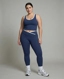 Woman wearing seamless sculpt high waist gym set with tank top and leggings in navy blue, shown from front and back.