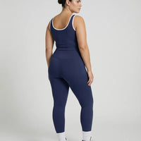 Woman wearing seamless sculpt high waist gym set with tank top and leggings in navy blue, shown from front and back.

