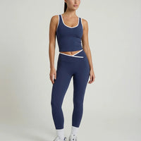 Woman wearing seamless sculpt high waist gym set with tank top and leggings in navy blue, shown from front and back.
