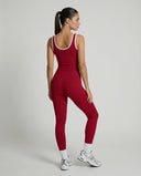 Woman wearing seamless sculpt high waist gym set with tank top and leggings in red, shown from front and back.