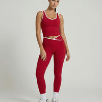 Woman wearing seamless sculpt high waist gym set with tank top and leggings in red, shown from front and back.