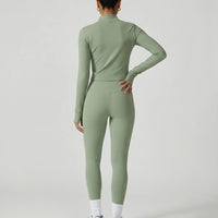 Woman wearing a seamless sculpting three piece activewear set with high waist leggings, sports bra, and fitted jacket paired with sneakers.