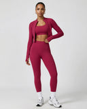 Woman wearing a seamless sculpting three piece activewear set with high waist leggings, sports bra, and fitted jacket paired with sneakers.