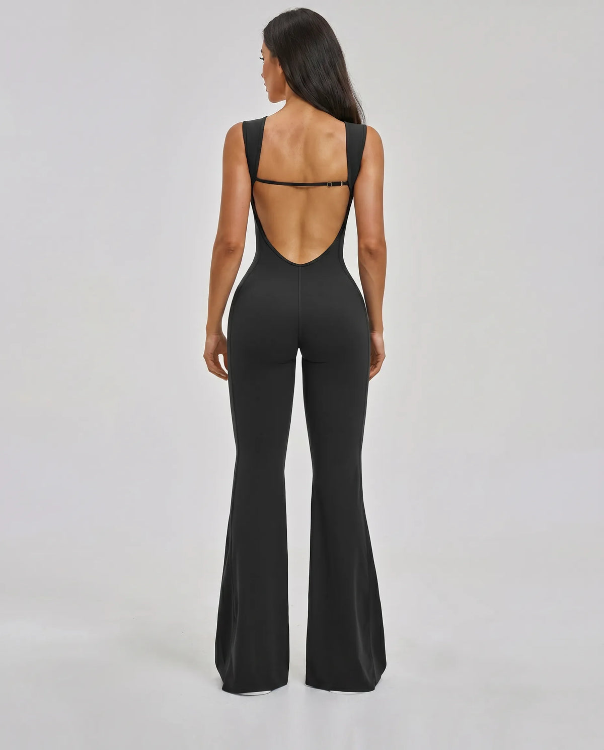 Ghost mannequin back view of the black backless bodysuit highlighting the open back cut and clean strap detail.