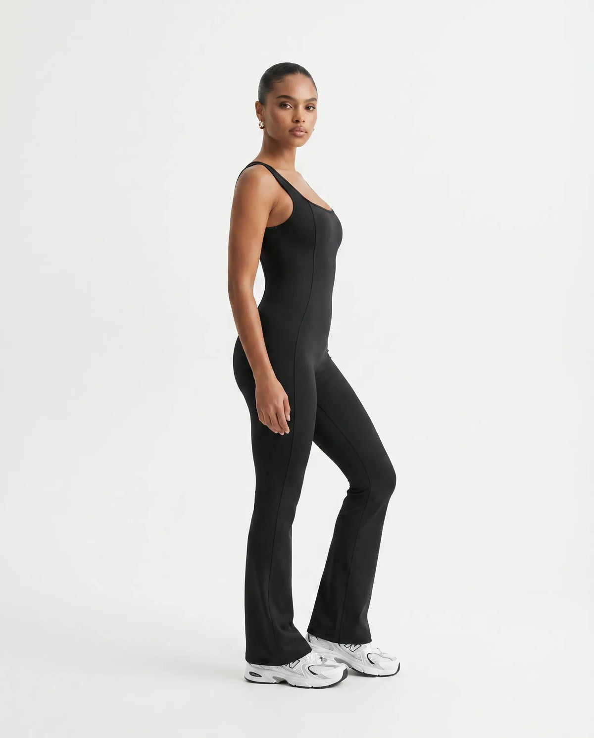Plus size model front view wearing the black backless bodysuit, showing how the compression fit sits across curves.