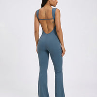 Back view of blue backless flare bodysuit on ghost mannequin highlighting open back cut and full-length flared legs.