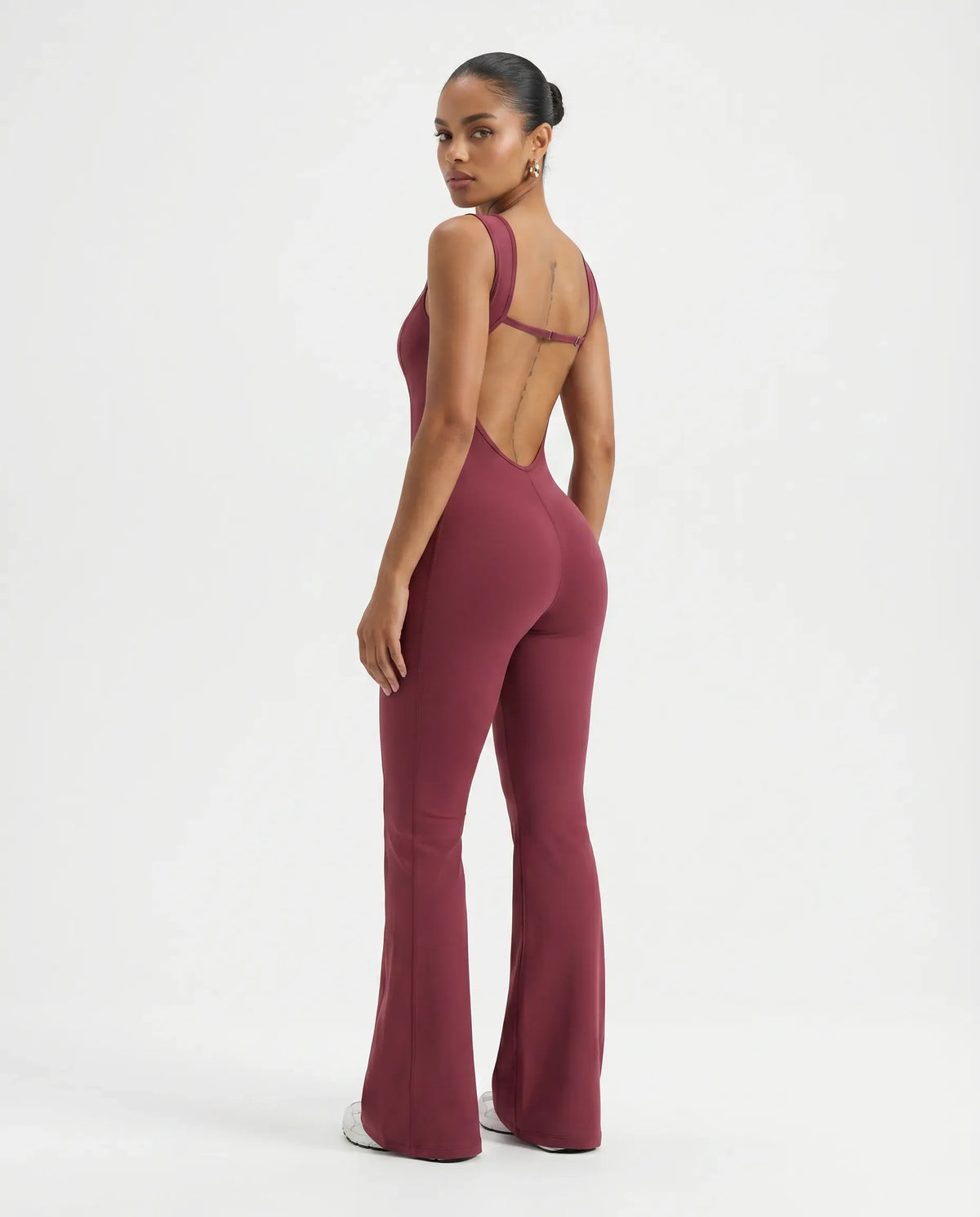 Back view of red backless bodysuit showing deep open-back design on a ghost mannequin.