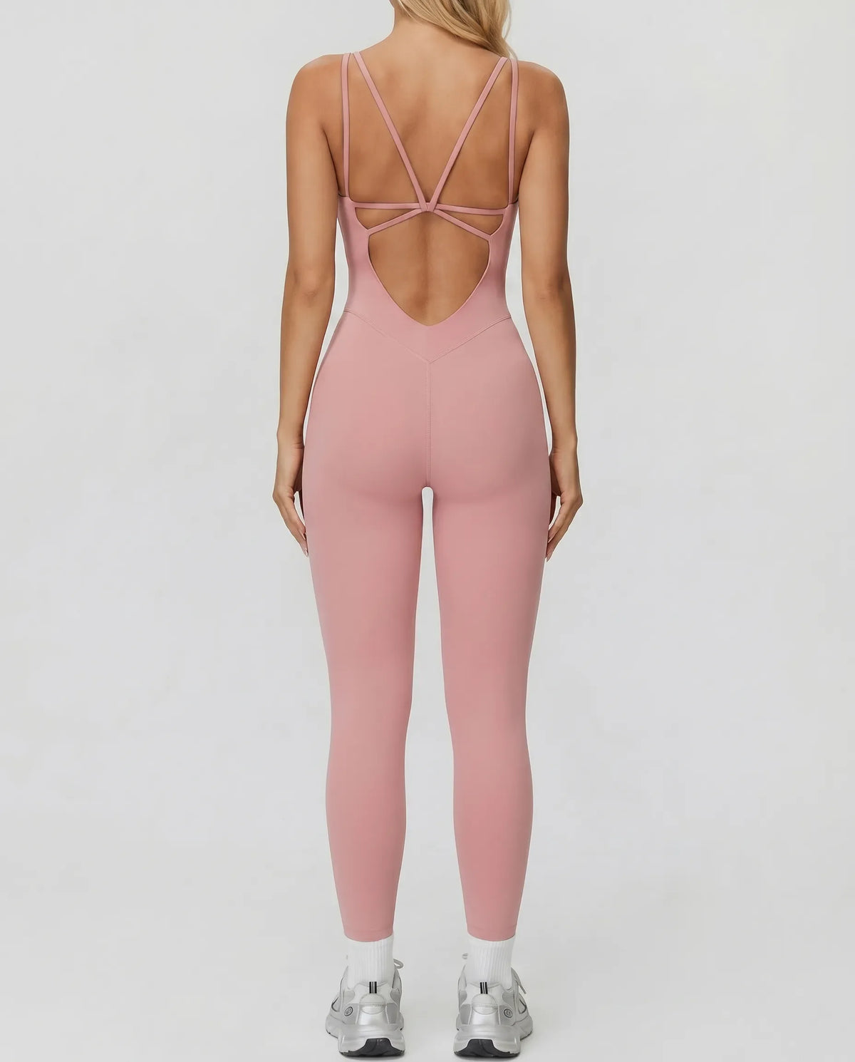 Ghost mannequin back view of pink backless bodysuit displaying open back detail and full-length leg.