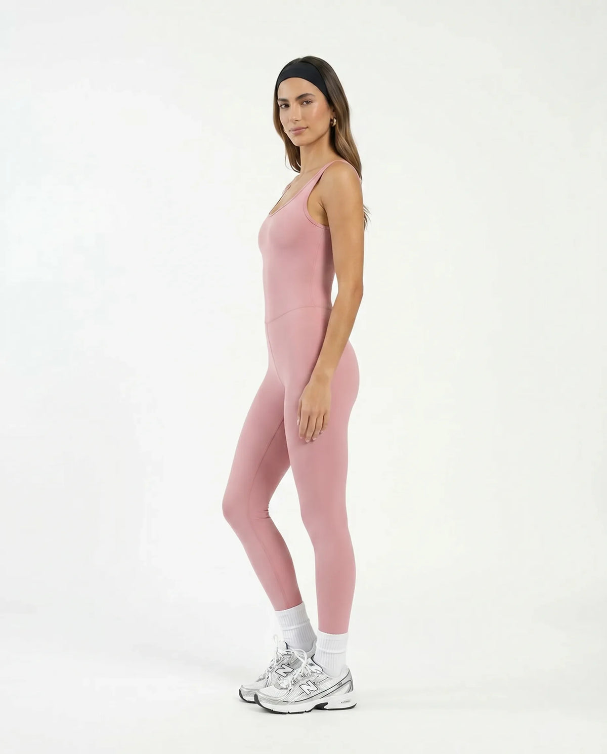 Plus size model front view wearing pink backless bodysuit in a studio setting showing inclusive fit.