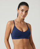 Blue sculpting sports bra top shown from the front on a ghost mannequin against a white background.
