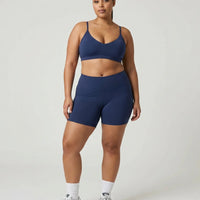 Model wearing the blue sculpting sports bra top, front view in a studio setting with neutral background.