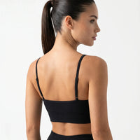 Ghost mannequin back view of a black V-neck sports bra showing crossed strap detail and clean finish.