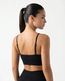 Ghost mannequin back view of a black V-neck sports bra showing crossed strap detail and clean finish.