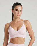 Ghost mannequin front view of pink ribbed sculpting bra top with thin adjustable straps and V-neckline.