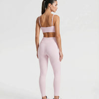Ghost mannequin back view of pink ribbed bra top showing crossed strap detail and seamless finish.