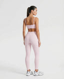 Ghost mannequin back view of pink ribbed bra top showing crossed strap detail and seamless finish.
