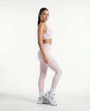 Plus size model wearing pink ribbed bra top, back studio view highlighting inclusive fit and strap detail.