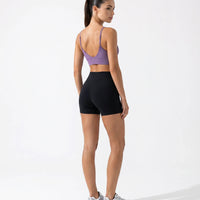 Ghost mannequin back view of purple seamless bra top and high waist leggings displaying thin strap detail and smooth back construction.
