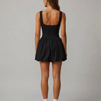 Back view of black balloon mini dress showing wide straps and gathered skirt on ghost mannequin.