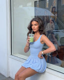 Plus size model back view wearing light blue balloon hem activewear dress highlighting inclusive fit and skirt shape.