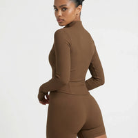 Back view of brown ribbed zip jacket on ghost mannequin highlighting tailored seaming and slim fit silhouette.