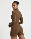 Back view of brown ribbed zip jacket on ghost mannequin highlighting tailored seaming and slim fit silhouette.