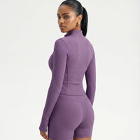 Ghost mannequin back view of purple ribbed activewear jacket and legging set displaying full back panel and waistband.