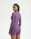 Ghost mannequin back view of purple ribbed activewear jacket and legging set displaying full back panel and waistband.