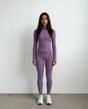 Plus size model back view in purple ribbed activewear set showing inclusive fit across hips and thighs.