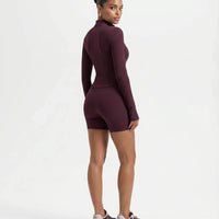 Back view of wine red sculpting zip-up jacket top on ghost mannequin displaying clean back panelling and long sleeves.