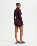 Back view of wine red sculpting zip-up jacket top on ghost mannequin displaying clean back panelling and long sleeves.