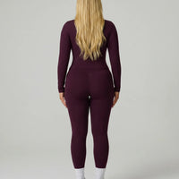 Model facing away wearing the wine red sculpting jacket top showing the sleek back profile and fitted silhouette.
