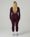 Model facing away wearing the wine red sculpting jacket top showing the sleek back profile and fitted silhouette.
