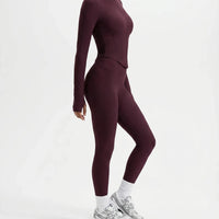 Plus size model front view wearing the wine red zip-up jacket top styled with matching high waist leggings.