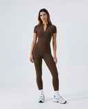 Ghost mannequin front view of black short-sleeve zip-front sculpting jumpsuit showing half-zip neckline and full-length legs.